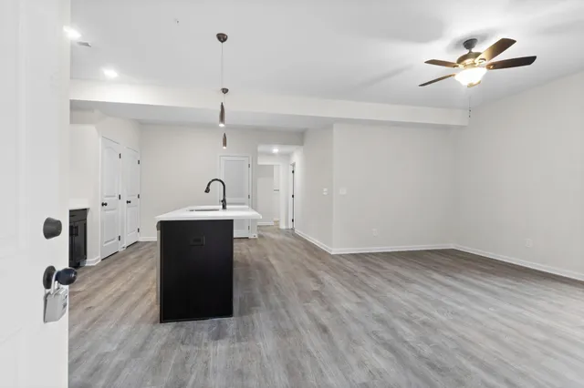 a view of a kitchen with sink and wooden floor