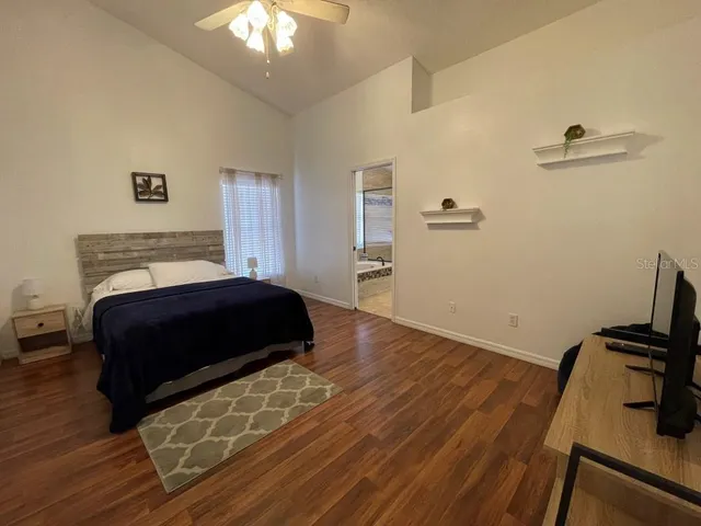a bedroom with a bed and wooden floor