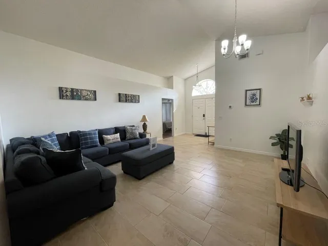 a living room with furniture and a chandelier