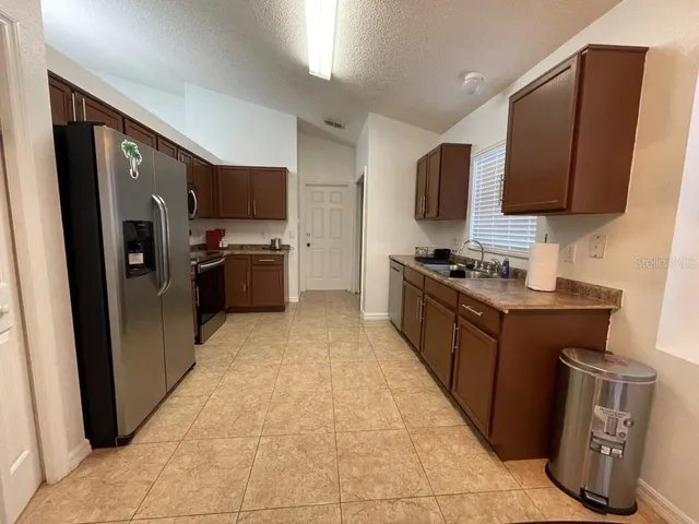 a large kitchen with a stove top oven a sink dishwasher and a refrigerator