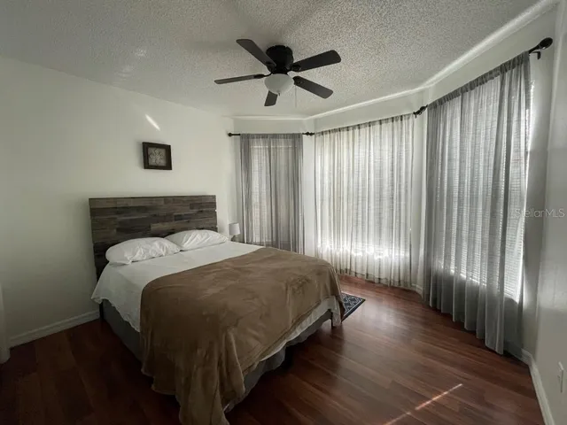a spacious bedroom with a bed and a ceiling fan