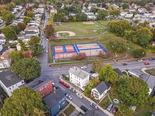 an aerial view of a residential houses with outdoor space and street view
