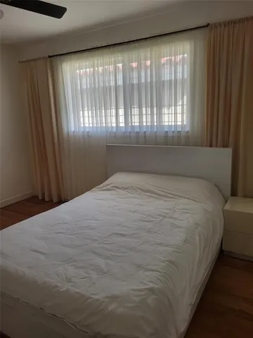 a large bed sitting in a bedroom next to a window