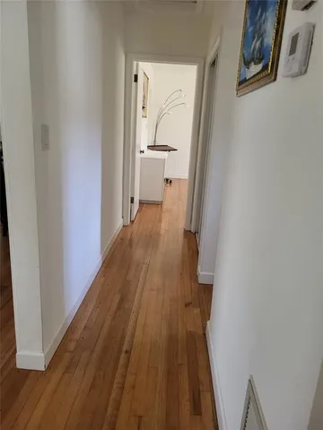 a view of a hallway with wooden floor and entryway