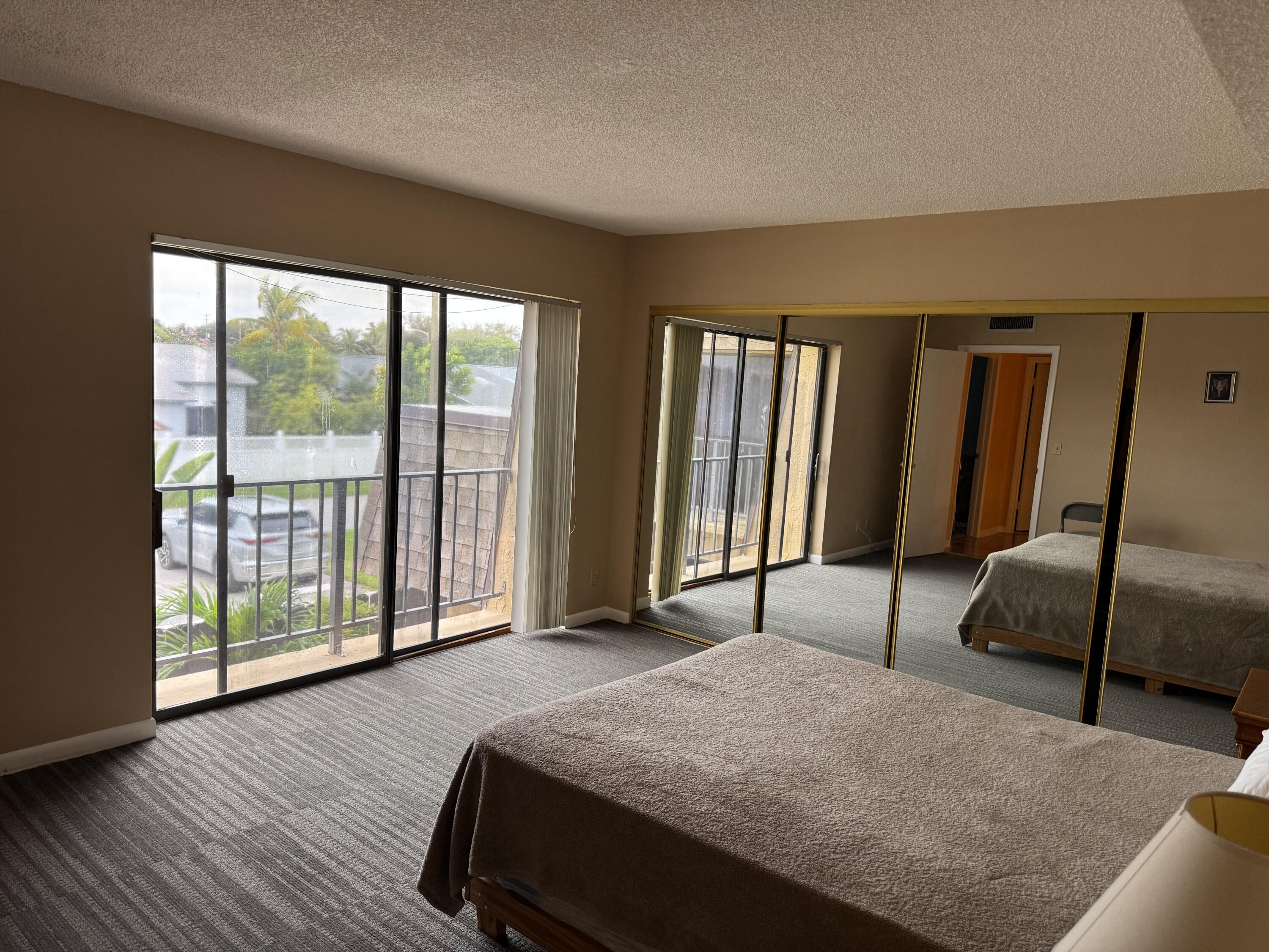 4101 Waterview Circle, Unit 41A Palm Springs, FL 33461 - Photo 14 of 26 a spacious bedroom with a large bed and a large window