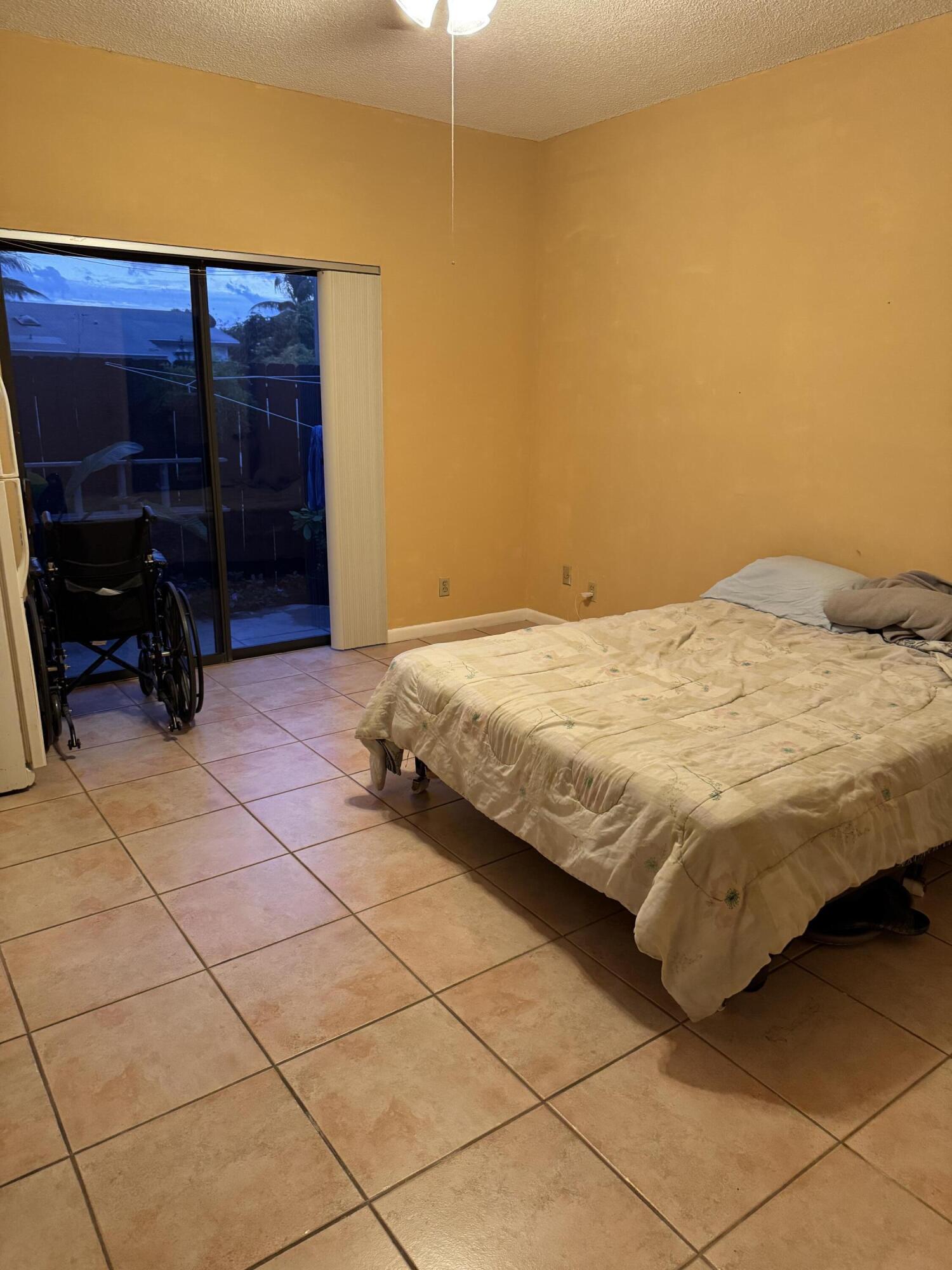 4101 Waterview Circle, Unit 41A Palm Springs, FL 33461 - Photo 23 of 26 a bedroom with a bed and a chair