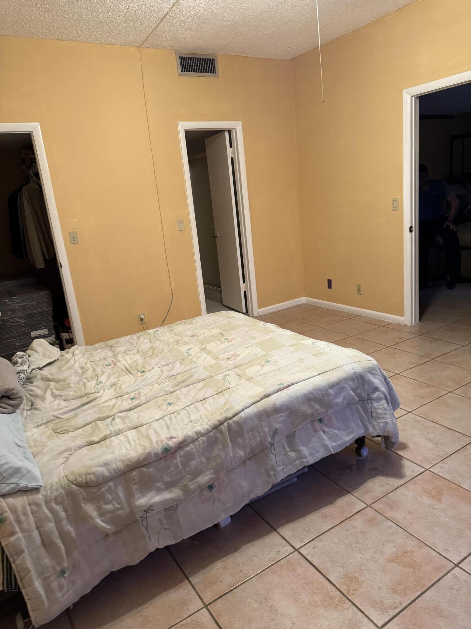 4101 Waterview Circle, Unit 41A Palm Springs, FL 33461 - Photo 24 of 26 a bedroom with a bed and a mirror