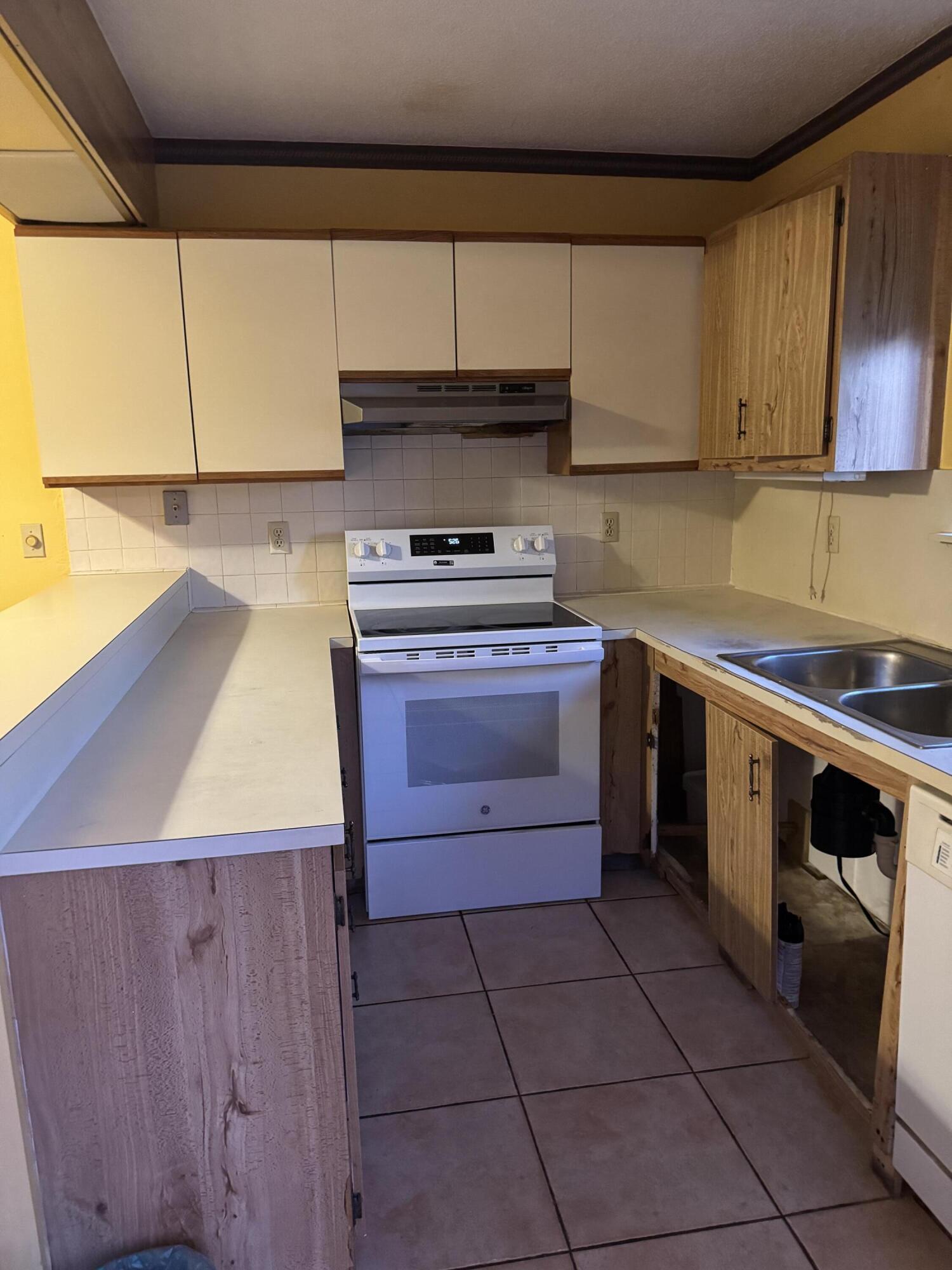 4101 Waterview Circle, Unit 41A Palm Springs, FL 33461 - Photo 7 of 26 a kitchen with a stove sink and cabinets