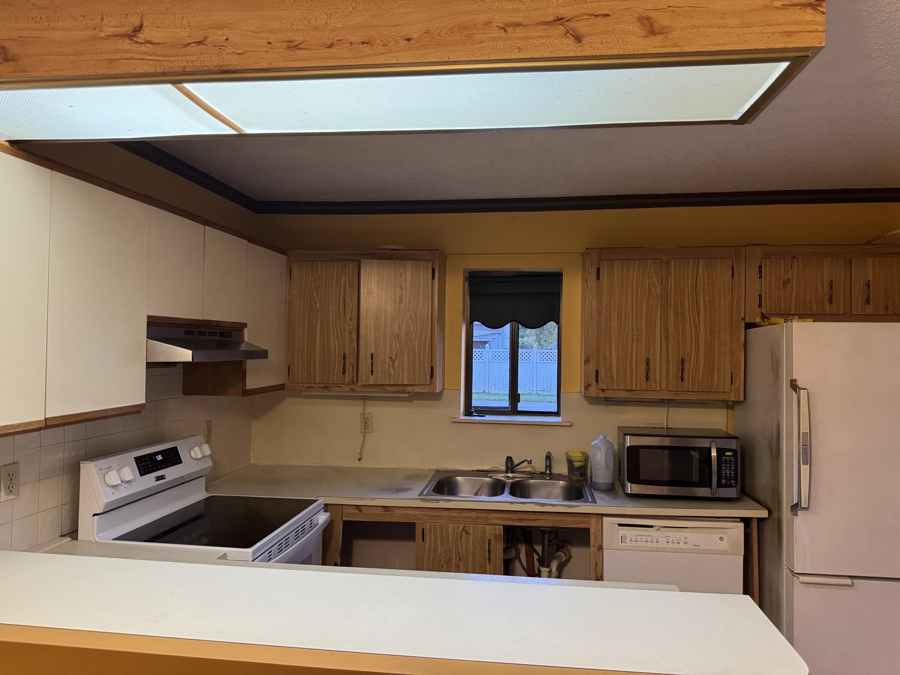 4101 Waterview Circle, Unit 41A Palm Springs, FL 33461 - Photo 8 of 26 a kitchen with a sink a refrigerator and cabinets