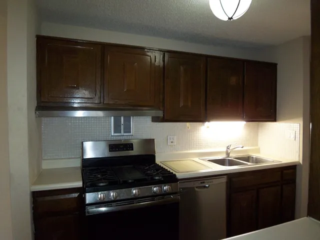 a kitchen with a sink a stove and cabinets