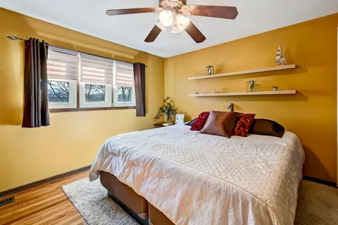 a bedroom with a bed and wooden floor