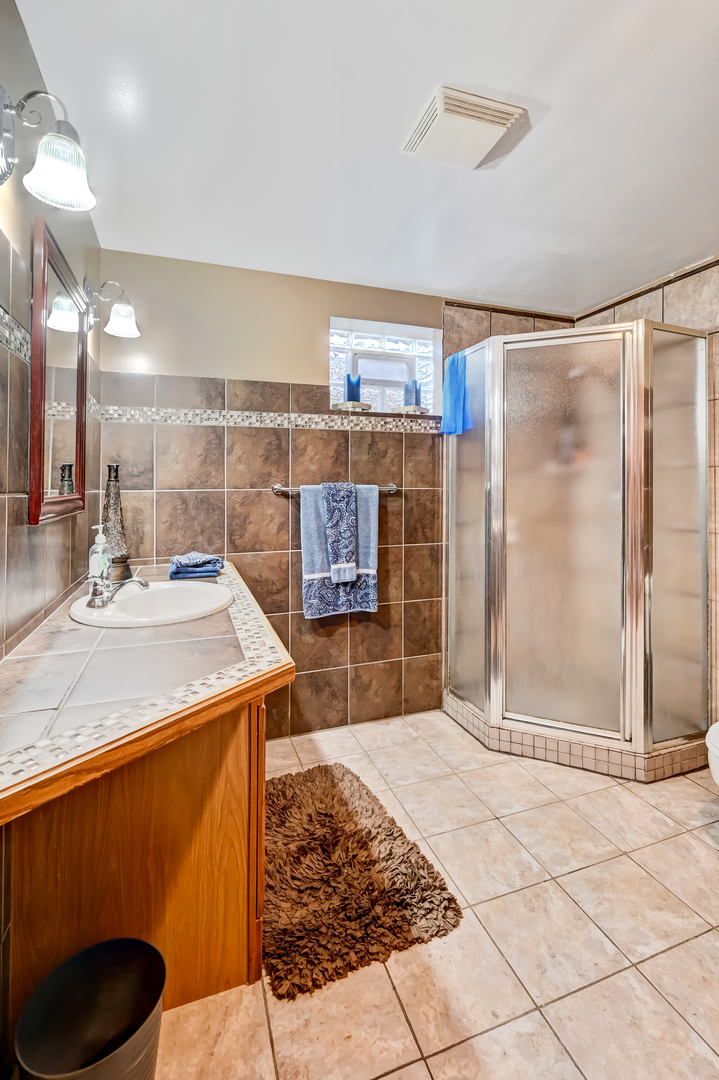 1435 Tomlin Drive Burr Ridge, IL 60527 - Photo 32 of 41 a bathroom with a sink a toilet and shower