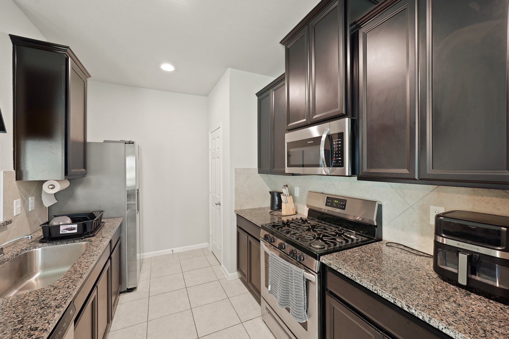 13303 Ardery Meadow Drive Houston, TX 77048 - Photo 12 of 33 a kitchen with granite countertop stainless steel appliances and wooden cabinets