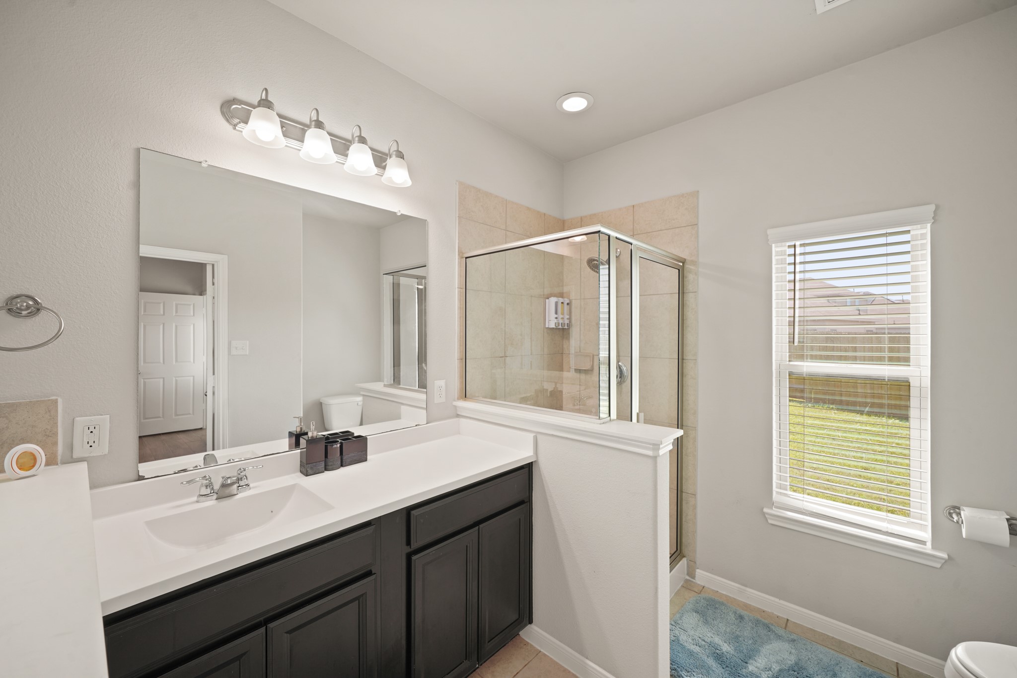 13303 Ardery Meadow Drive Houston, TX 77048 - Photo 18 of 33 a bathroom with a double vanity sink a mirror and a shower