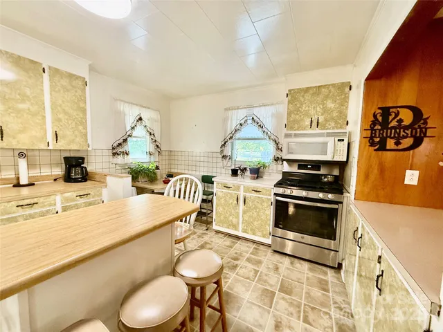 a kitchen with stainless steel appliances a stove a sink and a refrigerator