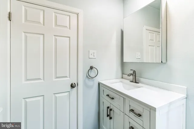 a bathroom with a sink vanity and a mirror