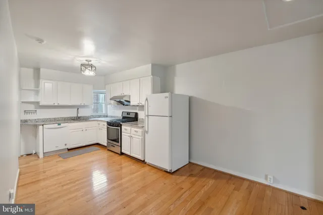 a kitchen with white cabinets and white appliances