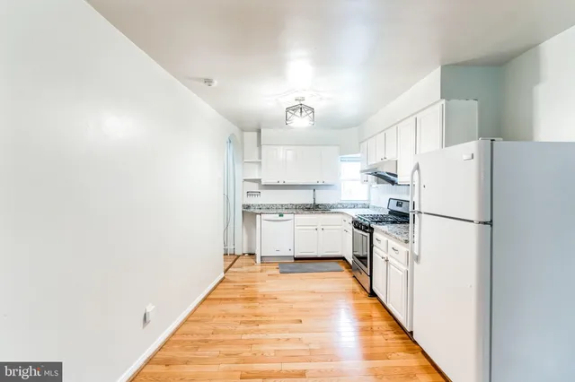 a kitchen with white cabinets and white appliances