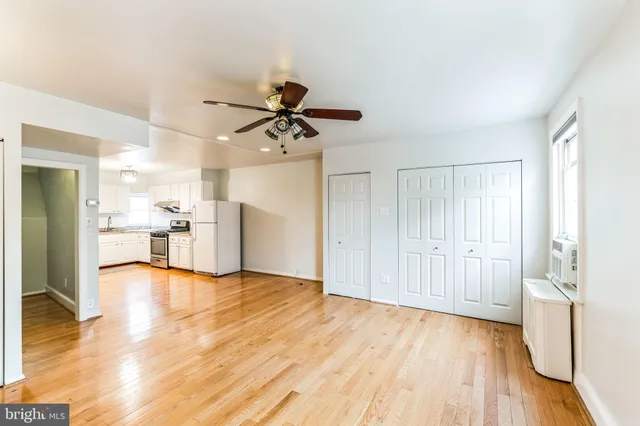 a view of a kitchen with wooden floor and a ceiling fan