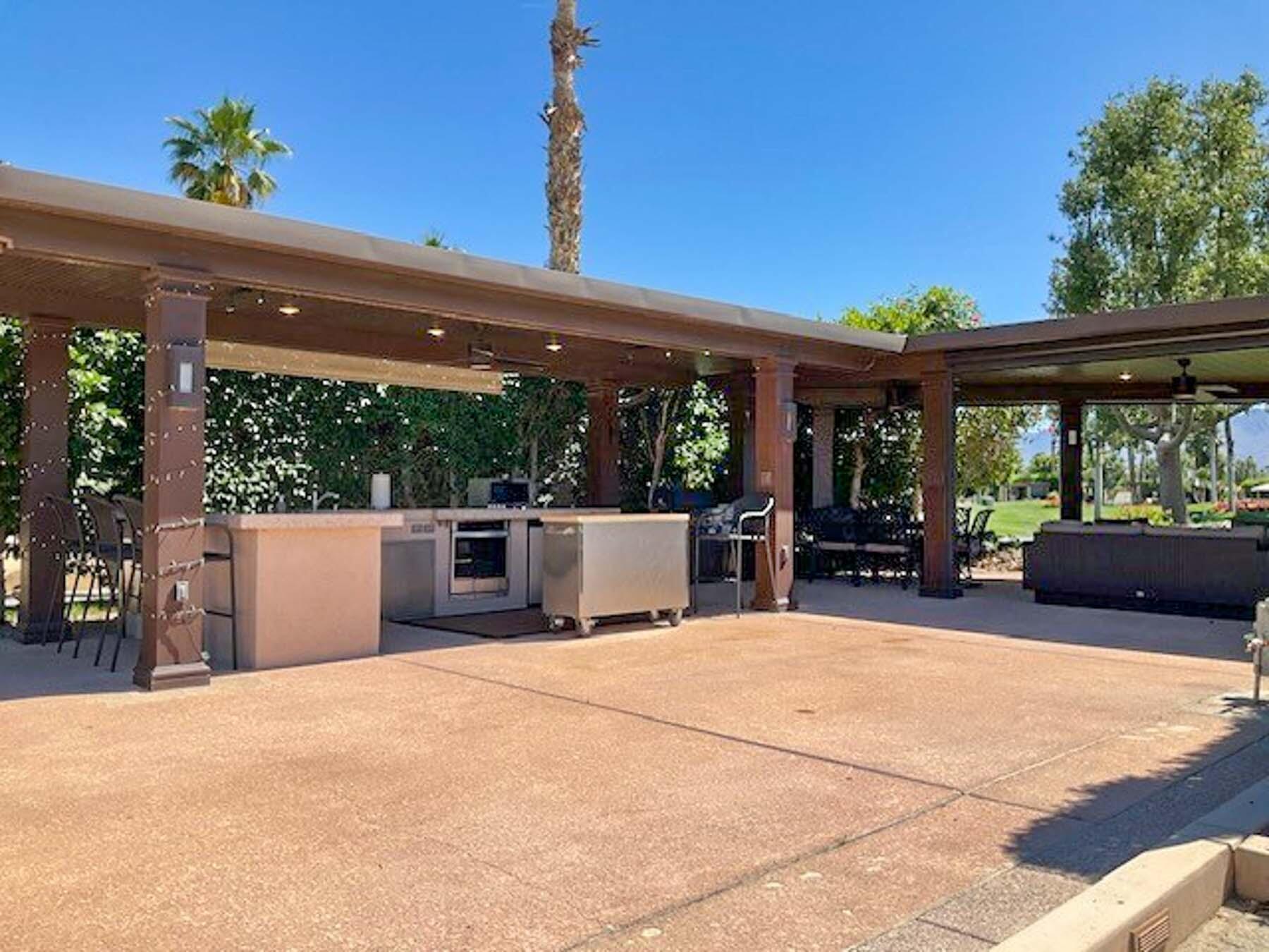 80394 Ave 48, Unit 234 Indio, CA 92201 - Photo 5 of 9 a view of a patio with a table and chairs under an umbrella with a small yard