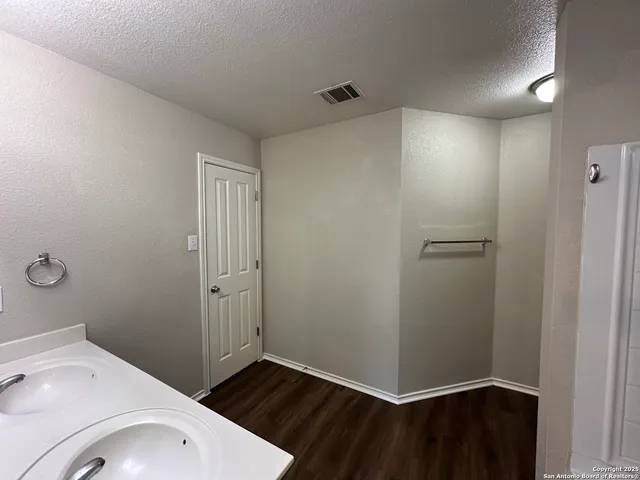 a bathroom with a double vanity sink a toilet and shower