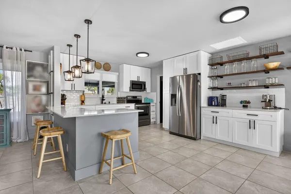 a kitchen with stainless steel appliances a refrigerator sink and cabinets