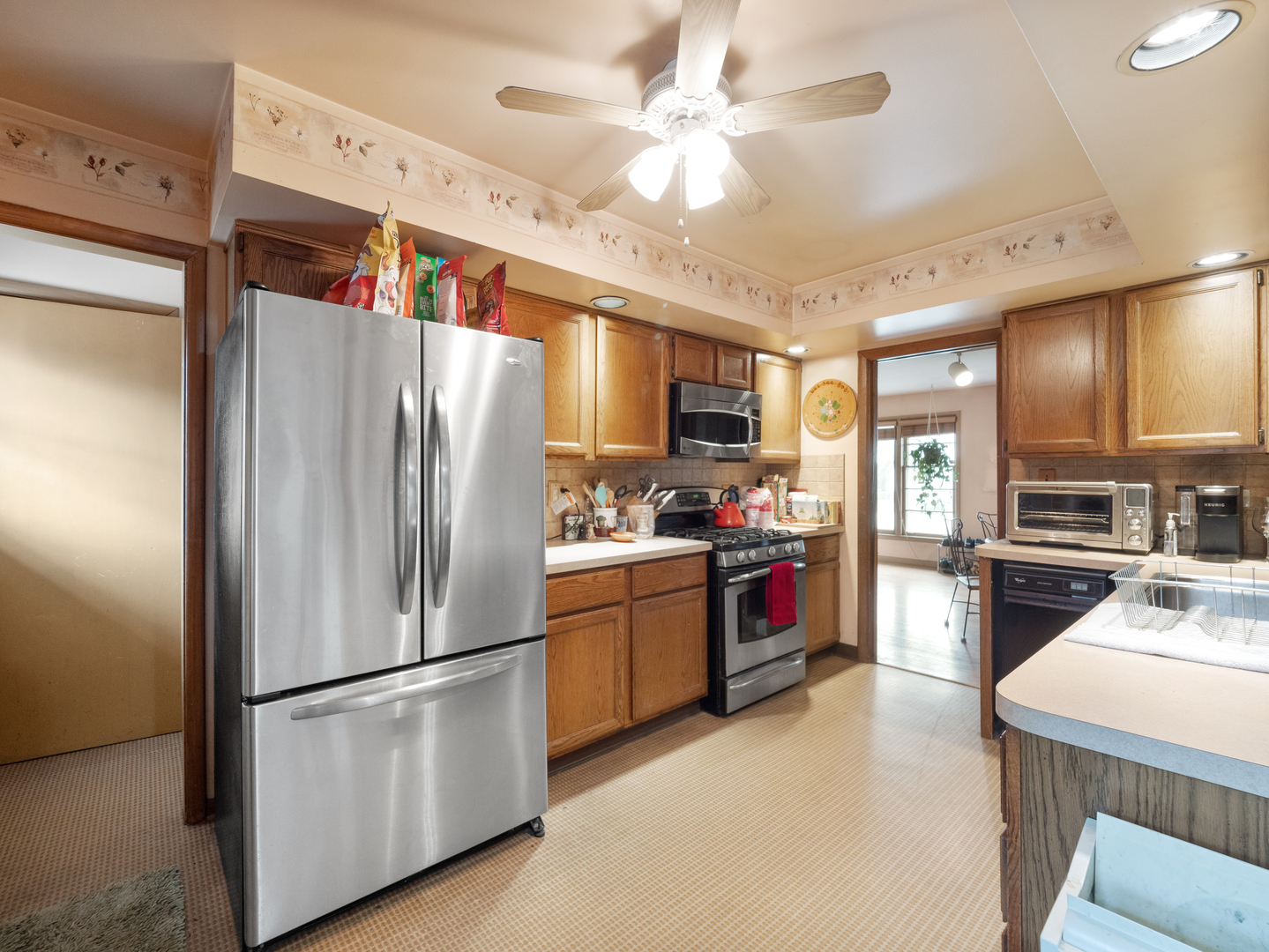 224 East Lahon Street Park Ridge, IL 60068 - Photo 7 of 25 a kitchen with a refrigerator a stove top oven a kitchen island and a dining table with wooden floor