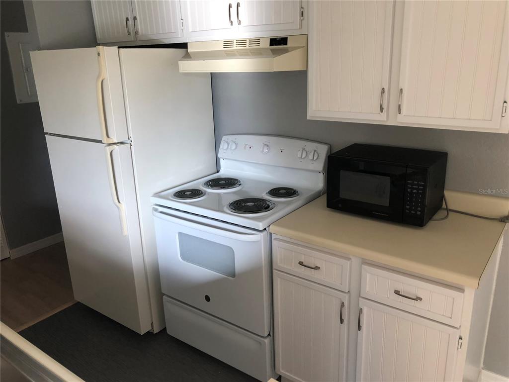 1037 South Hiawassee Road, Unit 2835 Orlando, FL 32835 - Photo 18 of 18 a kitchen with white cabinets and white appliances