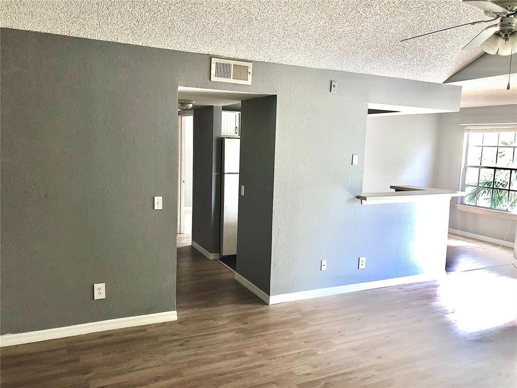 1037 South Hiawassee Road, Unit 2835 Orlando, FL 32835 - Photo 2 of 18 an empty room with wooden floor and windows