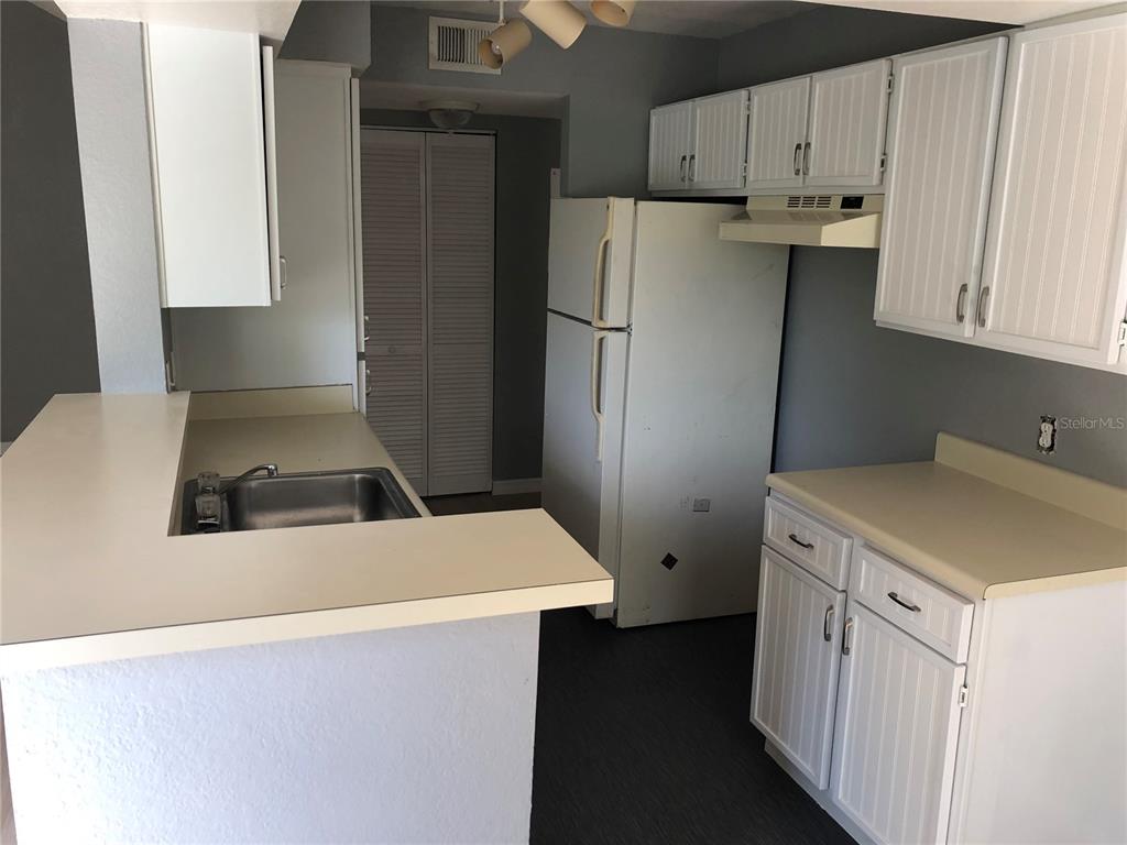 1037 South Hiawassee Road, Unit 2835 Orlando, FL 32835 - Photo 6 of 18 a kitchen with a refrigerator sink stove and cabinets