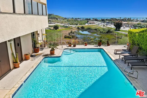 a view of a swimming pool and lounge chairs