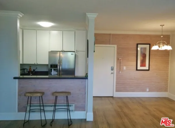 a kitchen with stainless steel appliances granite countertop a refrigerator and cabinets
