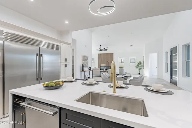 a kitchen with stainless steel appliances a sink a stove and white cabinets