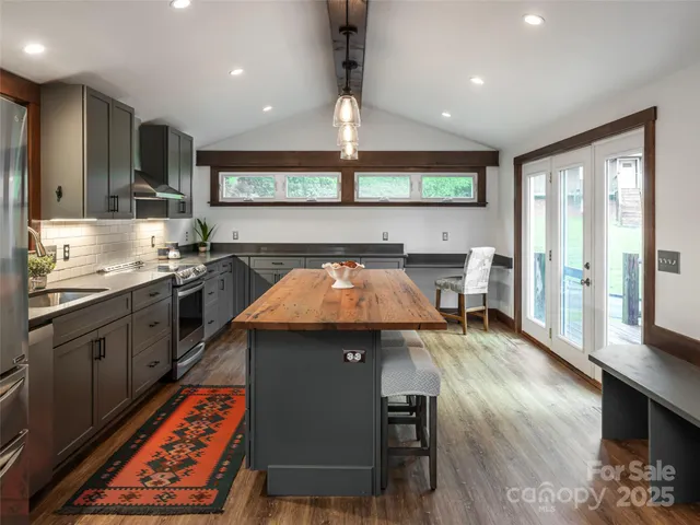a kitchen with stainless steel appliances granite countertop a sink counter space and wooden floor