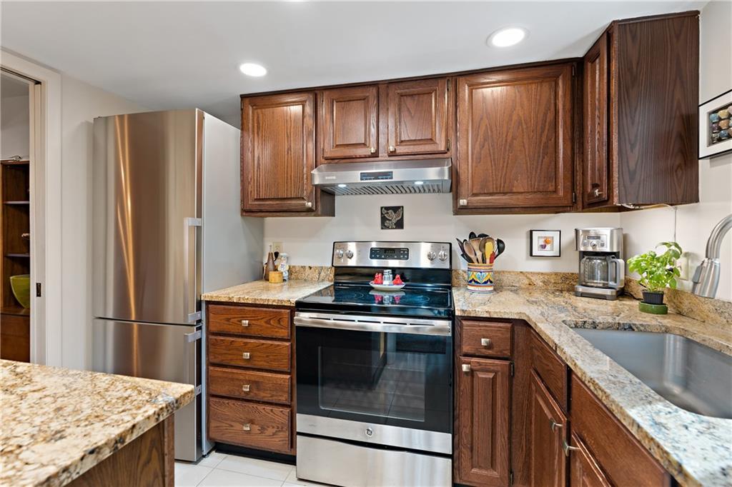 7 Foster Square Pittsburgh, PA 15212 - Photo 10 of 22 a kitchen with granite countertop wooden cabinets and stainless steel appliances