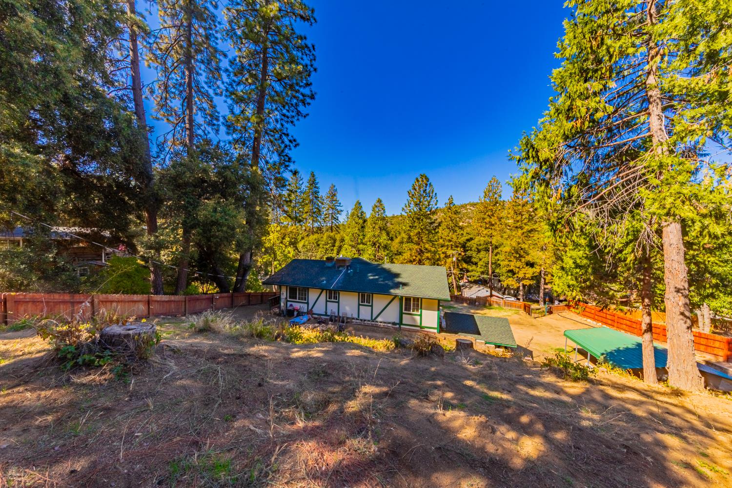 42585 Buckeye Road Oakhurst, CA 93644 - Photo 46 of 55 a backyard of a house with table and chairs under an umbrella