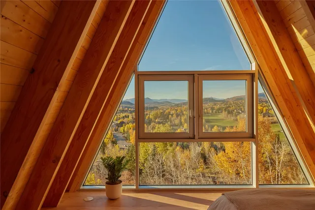 a bedroom with a bed and a large window