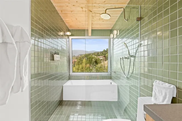 a bedroom with a bed and a large window with outer view