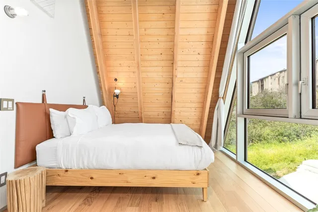 a bedroom with a bed and a potted plant
