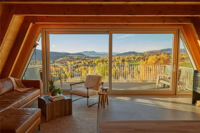 a living room with furniture and a floor to ceiling window