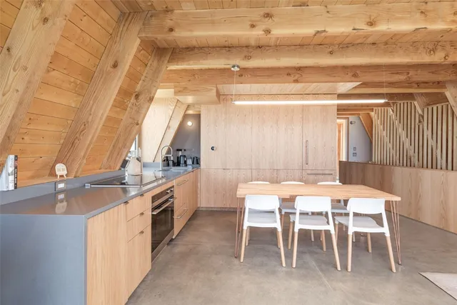 a dining area with a table chairs and kitchen view