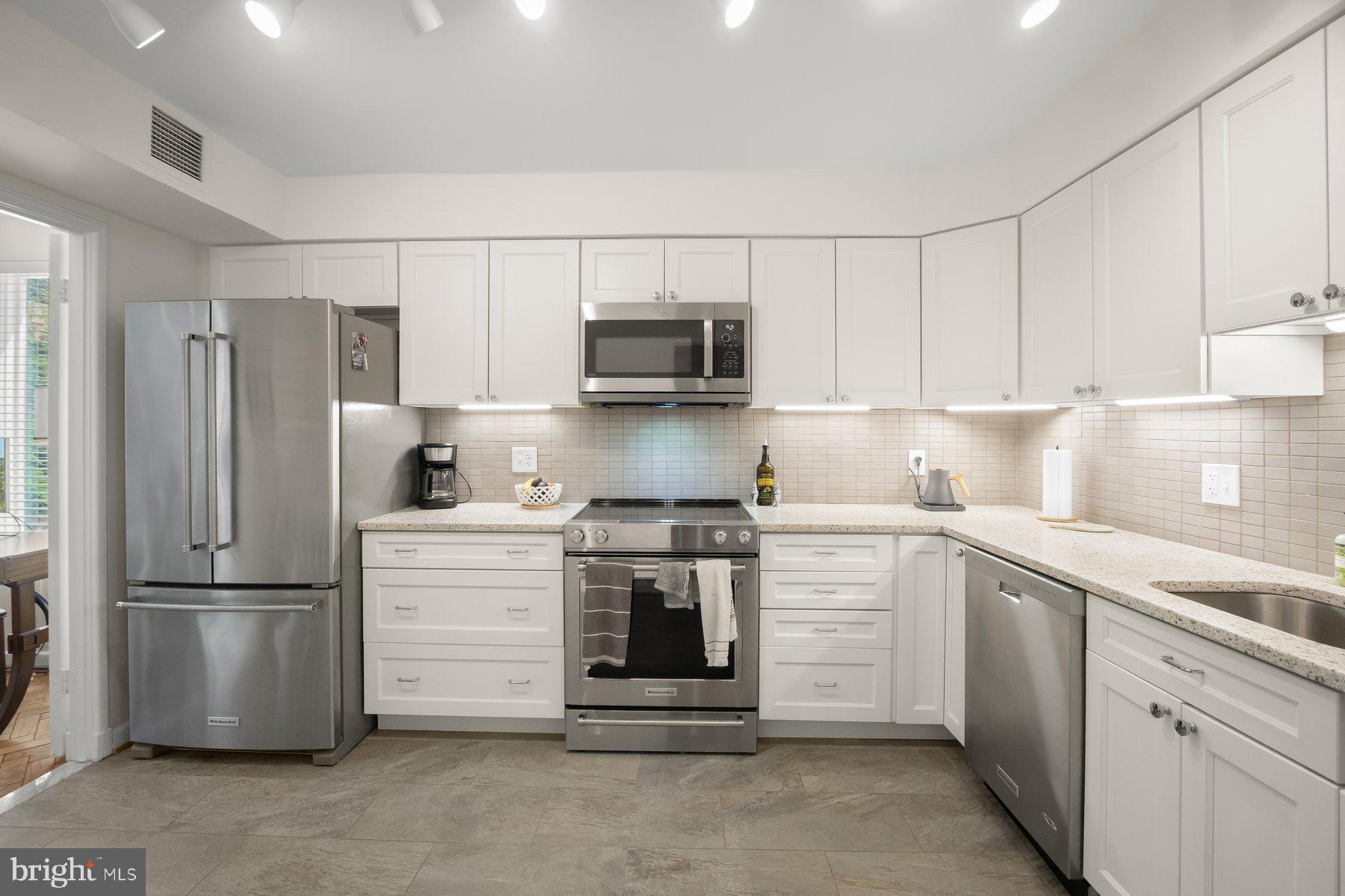 1045 31st Street Northwest, Unit 303 Washington, DC 20007 - Photo 5 of 12 a kitchen with stainless steel appliances white cabinets and a refrigerator