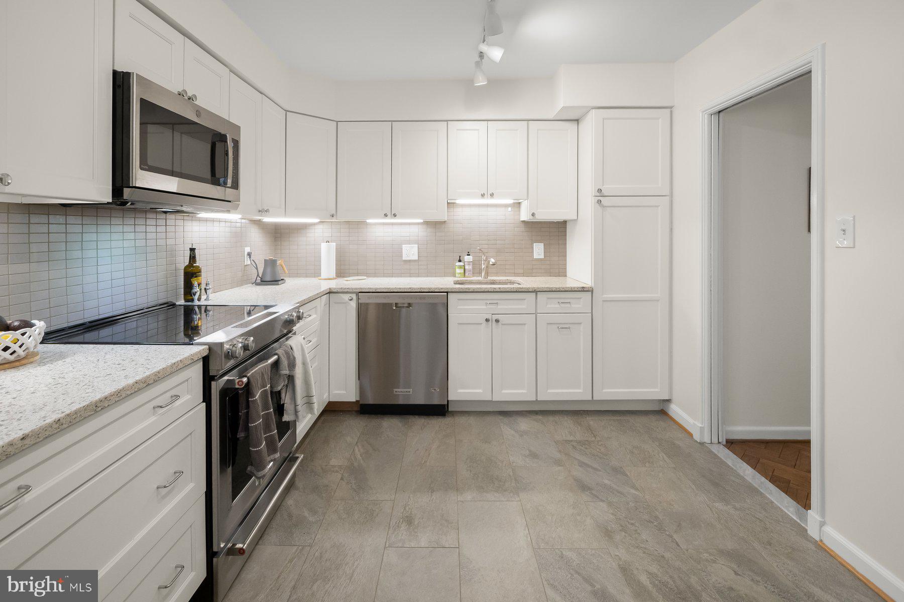 1045 31st Street Northwest, Unit 303 Washington, DC 20007 - Photo 6 of 12 a kitchen with a sink stove top oven and cabinets