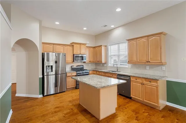 a kitchen with stainless steel appliances granite countertop a stove a sink a refrigerator and a microwave