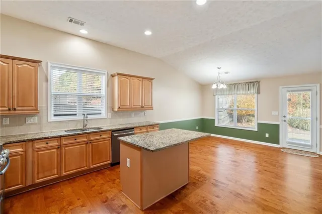 a open kitchen with granite countertop window sink and cabinets