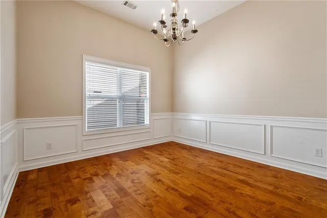 a view of a livingroom with an empty space & chandelier fan