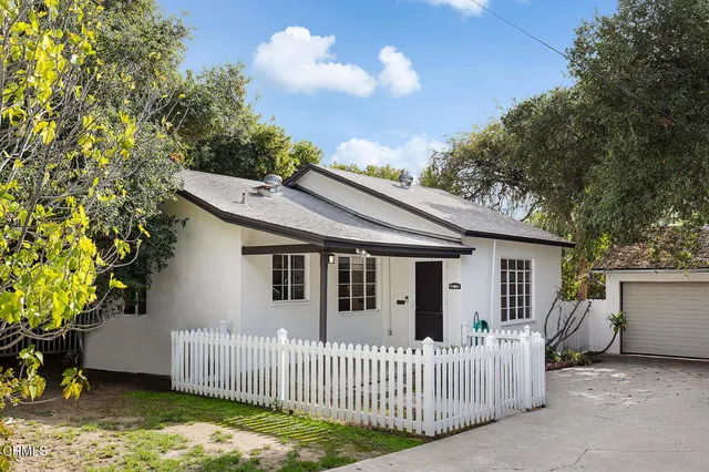 a view of a house with a small yard and wooden fence