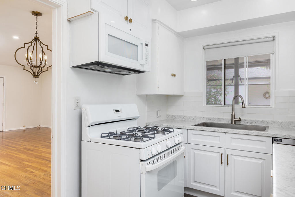 1070 East Woodbury Road Pasadena, CA 91104 - Photo 14 of 28 a kitchen with stainless steel appliances granite countertop a sink a stove and a window