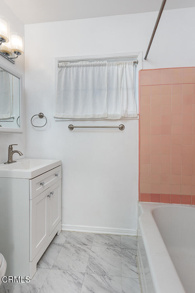 1070 East Woodbury Road Pasadena, CA 91104 - Photo 23 of 28 a bathroom with a sink a mirror and shower