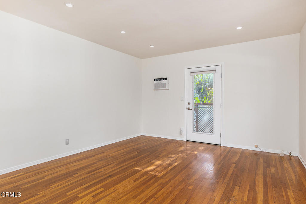 1070 East Woodbury Road Pasadena, CA 91104 - Photo 8 of 28 an empty room with wooden floor and windows